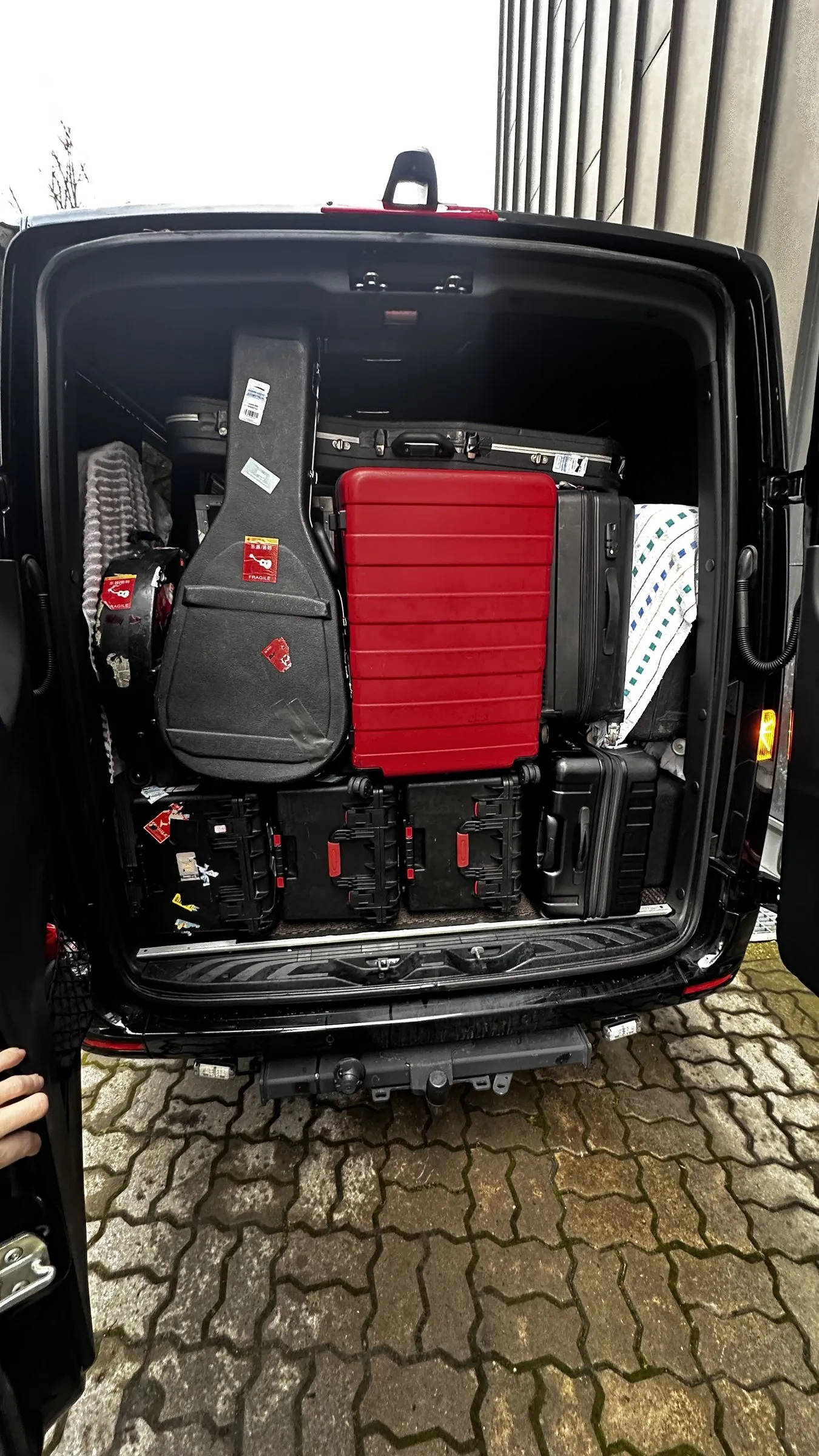 Guitar cases and hard cases secured in the Sprinter luggage bay