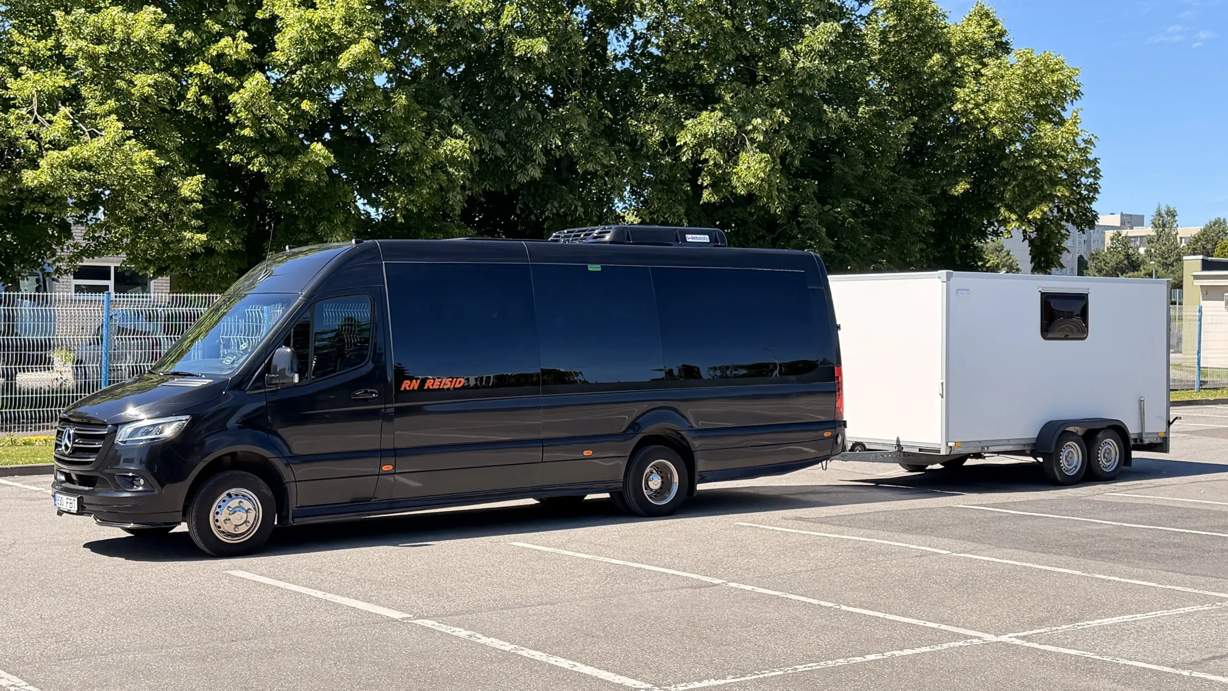 Mercedes-Benz Sprinter minibus with the SoloTransfer closed equipment trailer — sport event transfers in Estonia